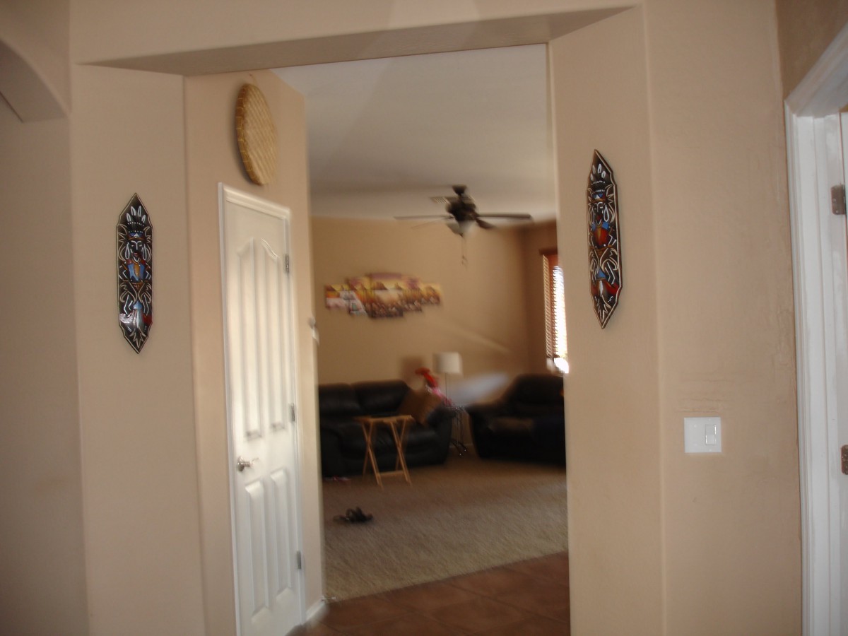 A view into a living room through a doorway, with visible furniture and wall decorations.