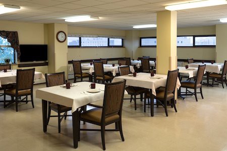 An empty dining room with neatly arranged tables and chairs.