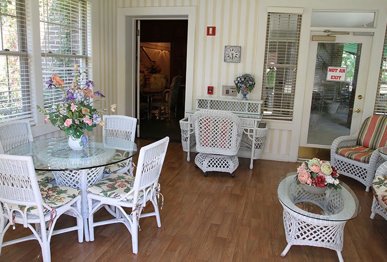A cozy indoor seating area with wicker furniture and floral decor.