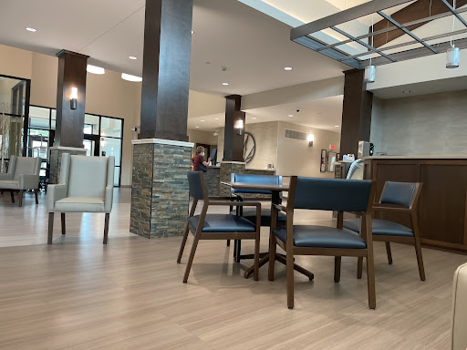 A modern waiting area featuring wooden flooring and contemporary furniture.