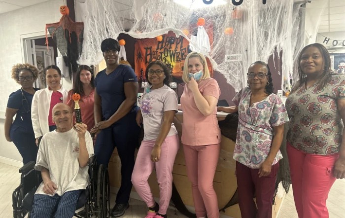 A group of people dressed up in front of Halloween decorations.