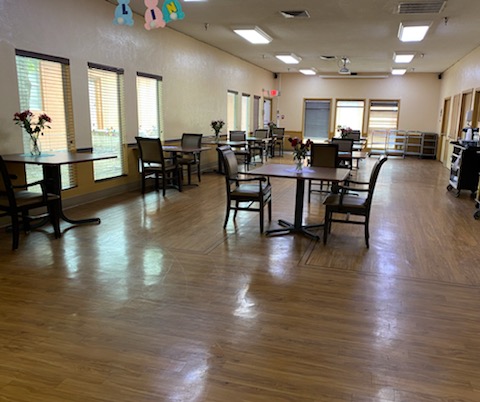 A spacious and well-lit dining area with tables and chairs arranged for use.