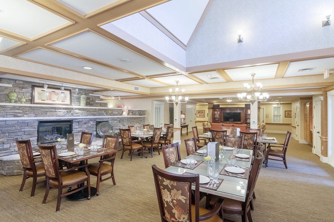 A well-lit restaurant dining area with elegantly set tables and comfortable seating.