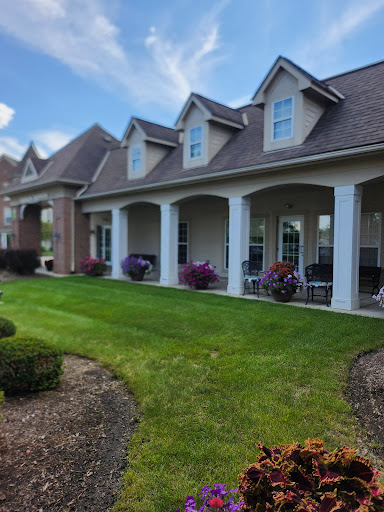 A beautifully landscaped house featuring a charming porch and vibrant flowers.
