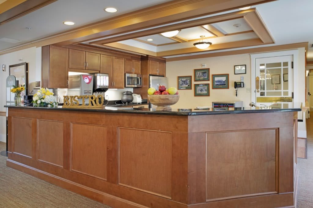 A hotel reception desk with a wooden design and warm lighting.