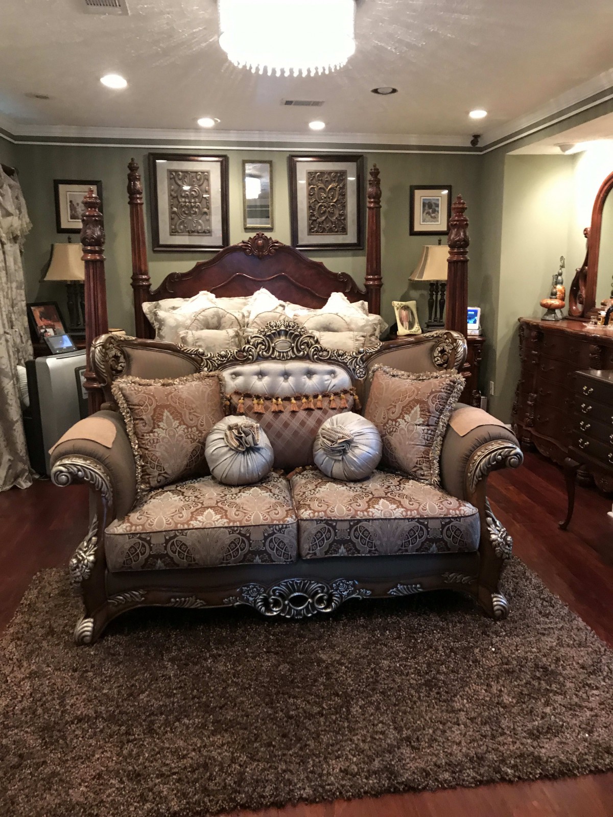 A luxurious bedroom with traditional furnishings, featuring a plush sofa and ornate decor.