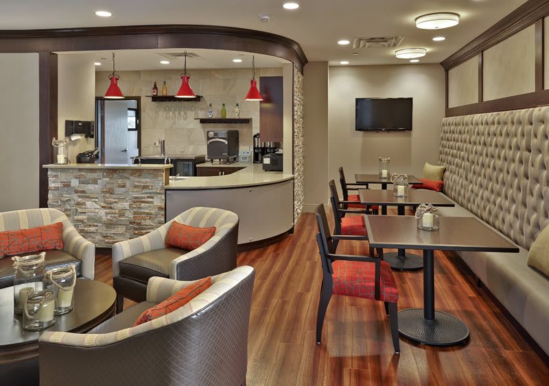 A modern cafe interior with cozy seating and wooden flooring.