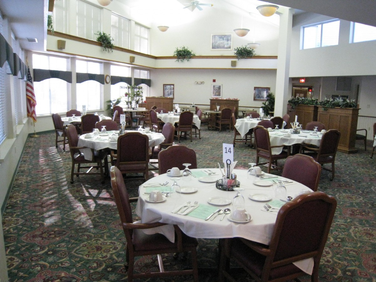 A well-lit restaurant dining area with neatly set tables and chairs.