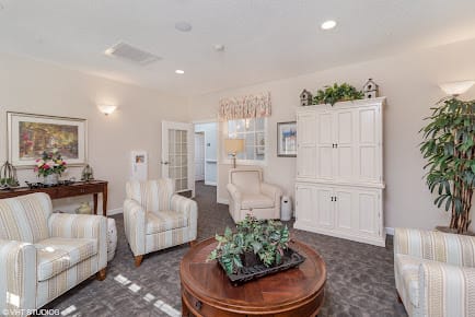 A cozy living room with comfortable chairs, a wooden coffee table, and elegant decor.