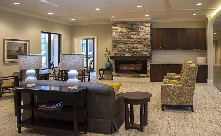 A modern living room with a stone fireplace and comfortable seating.