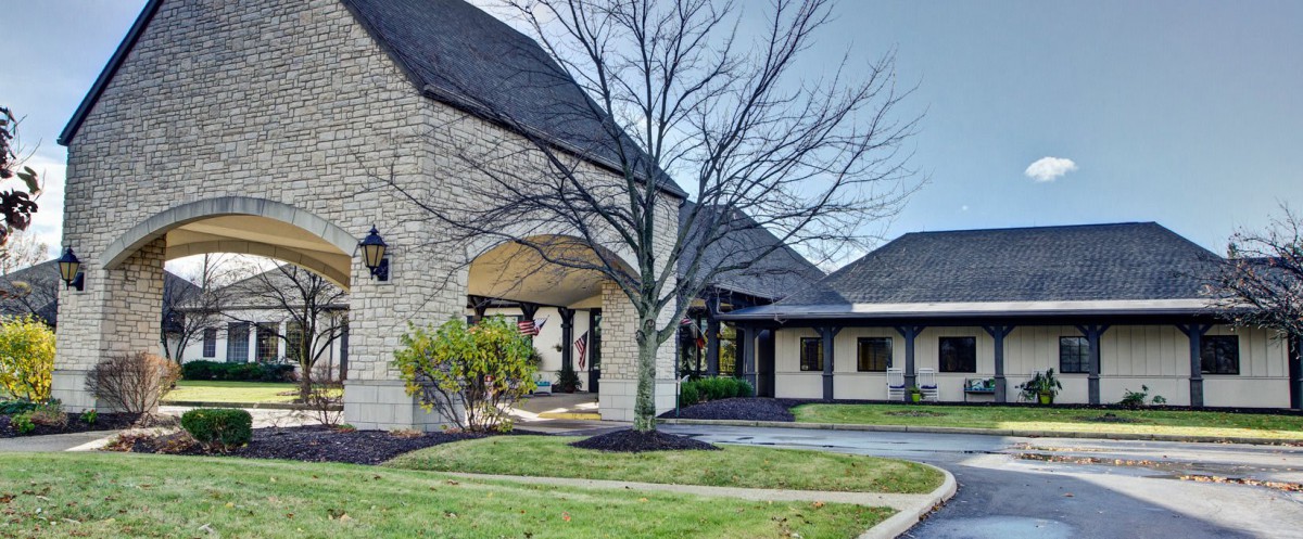 A modern building with stone facade and landscaped surroundings.