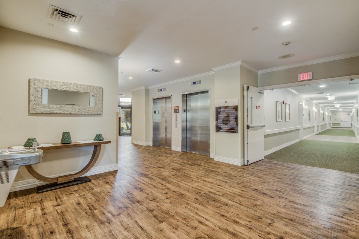 Modern lobby interior with wood flooring and elevators.