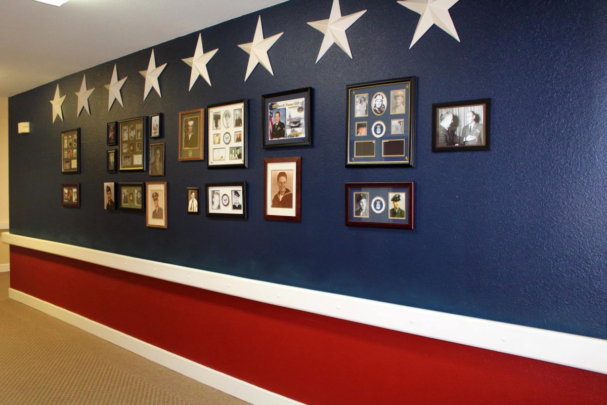 A wall decorated with military memorabilia and photographs, featuring a patriotic color scheme with stars.