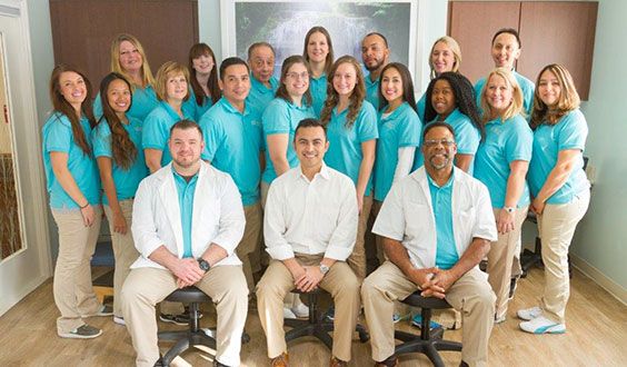A group of professionals posing for a team photo in an office setting.