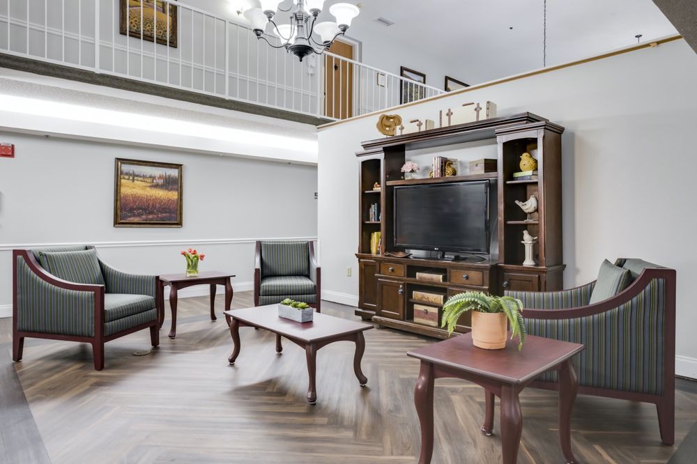 A traditional living room with an entertainment center, two chairs, and a coffee table.