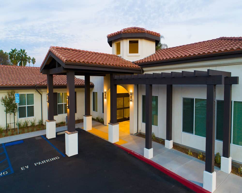 A modern building with a tiled roof and spacious entrance.