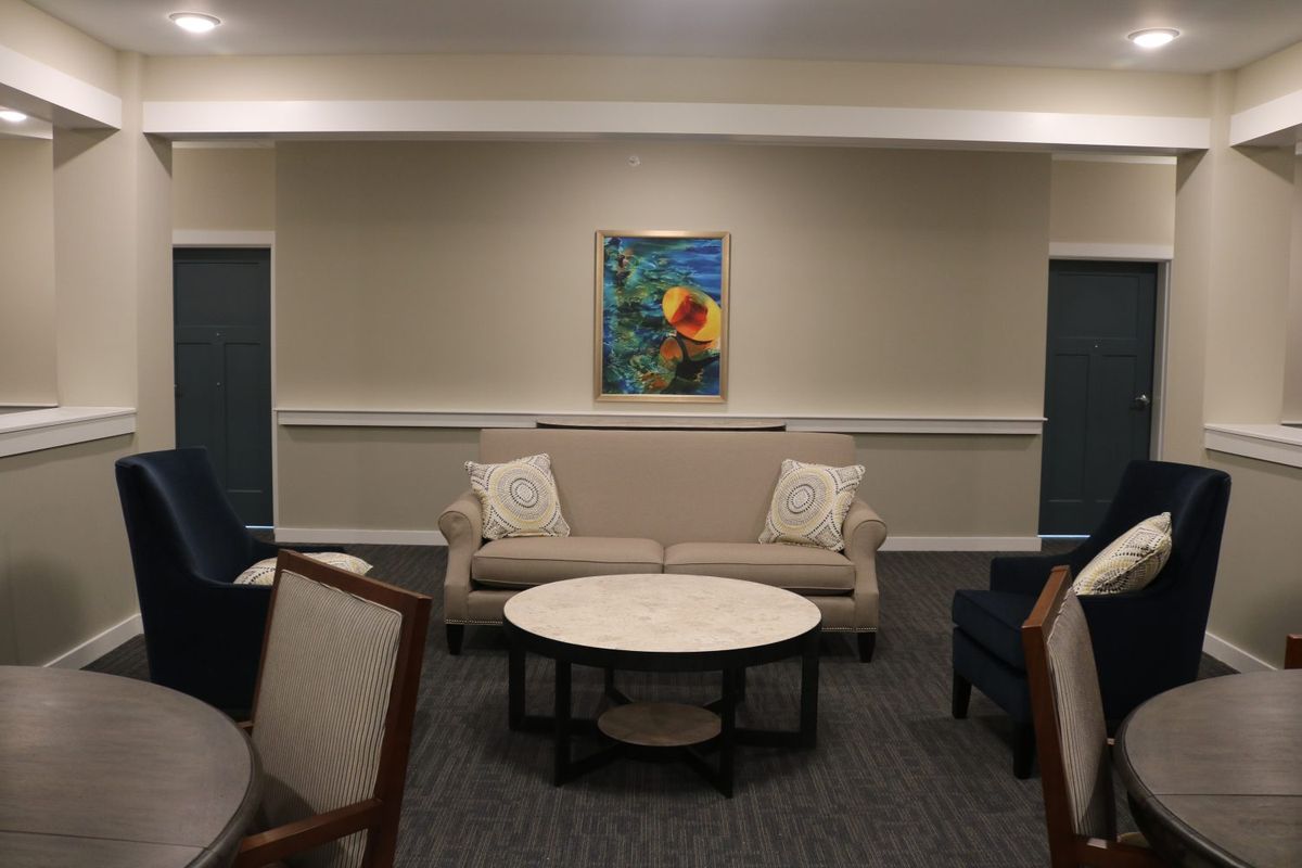 A cozy, modern living room with a sofa, coffee table, and framed artwork on the wall.