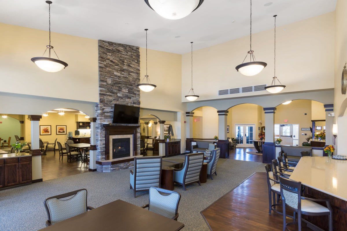 A spacious and modern lounge area with a fireplace and ample seating.