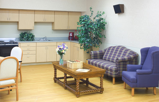 A cozy waiting area featuring comfortable seating, a wooden coffee table, and decorative plants.