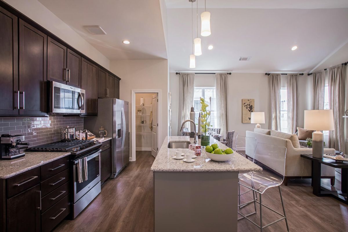A modern kitchen with an open concept design featuring an island counter and stainless steel appliances.