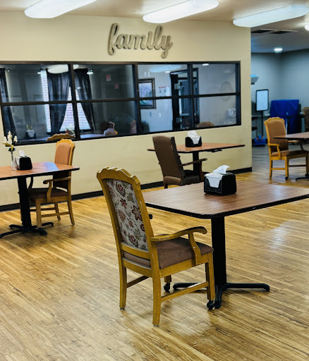 A spacious dining area designed for family gatherings, featuring empty tables and comfortable chairs.