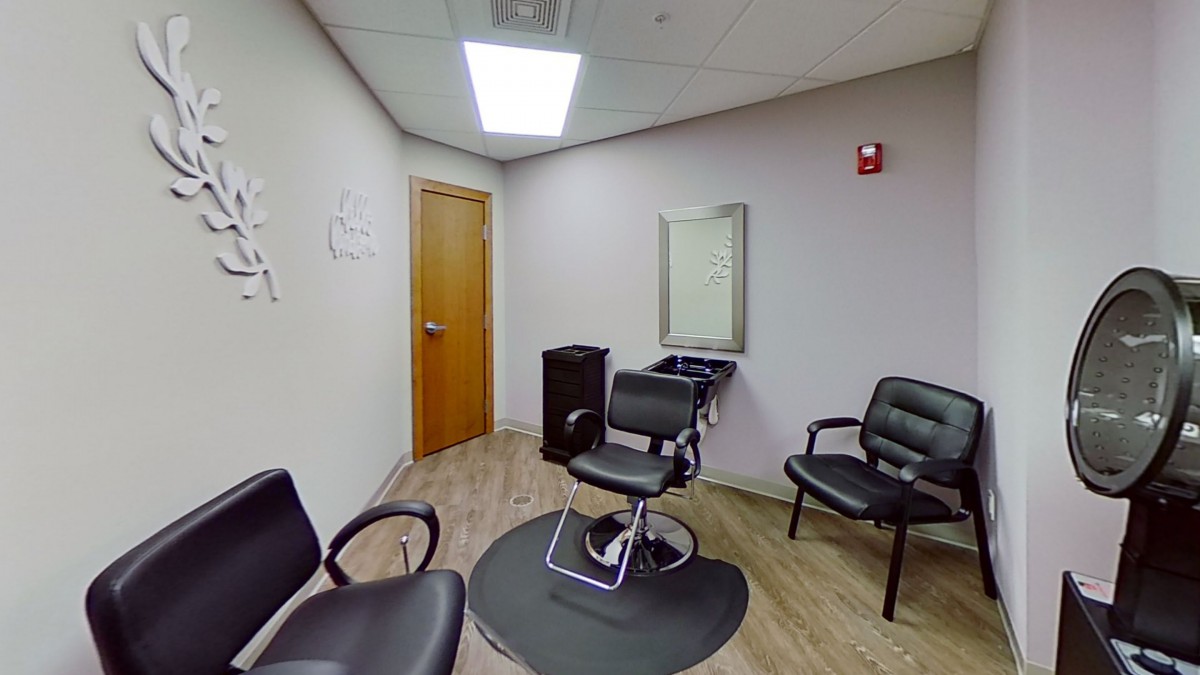 A cozy hair salon interior with a barber chair and waiting area.