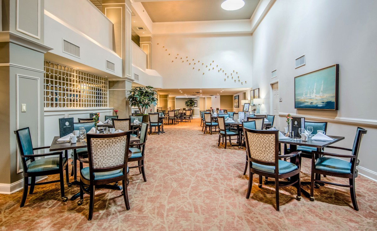 A spacious and elegantly decorated dining area with neatly arranged tables and chairs.