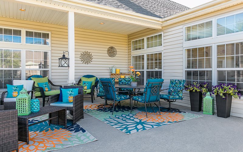 A cozy outdoor patio with vibrant furniture and decorative elements.