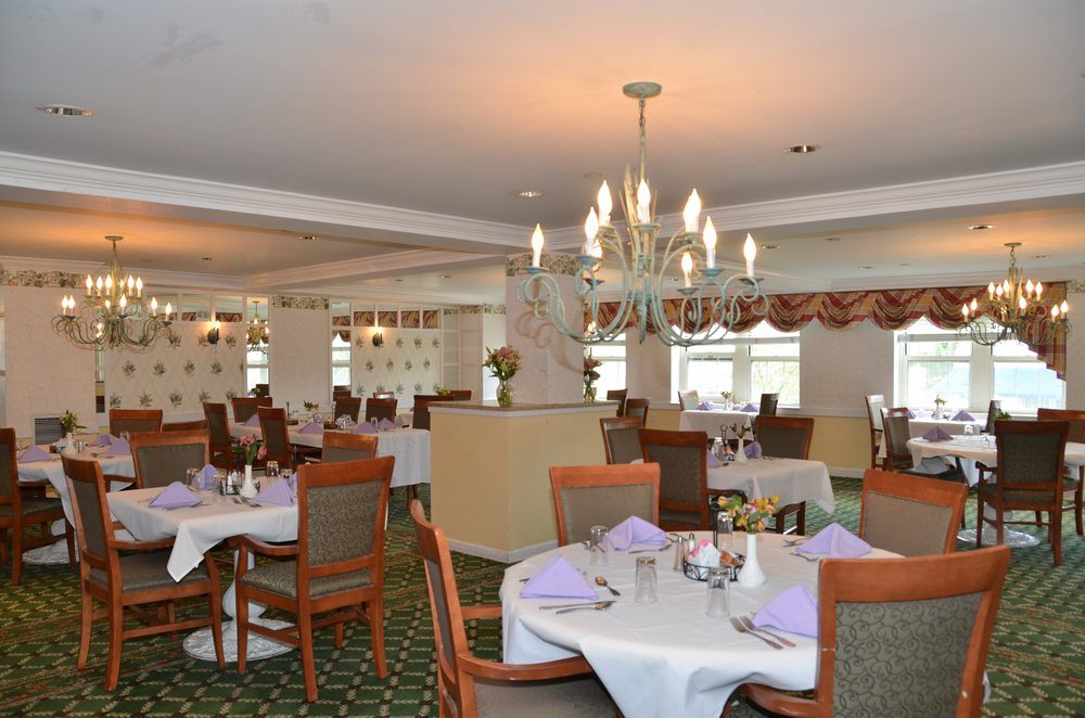 An elegant dining room with neatly arranged tables and a chandelier.
