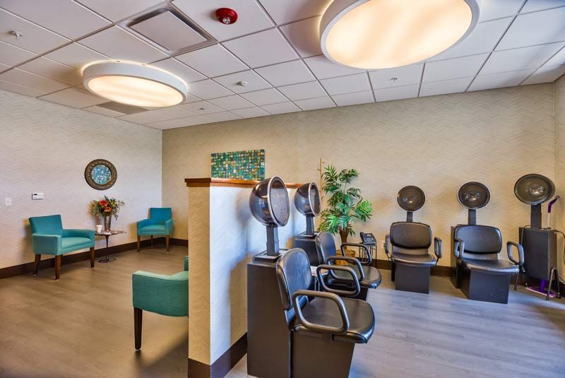 Modern salon interior with hair drying stations and a cozy waiting area.