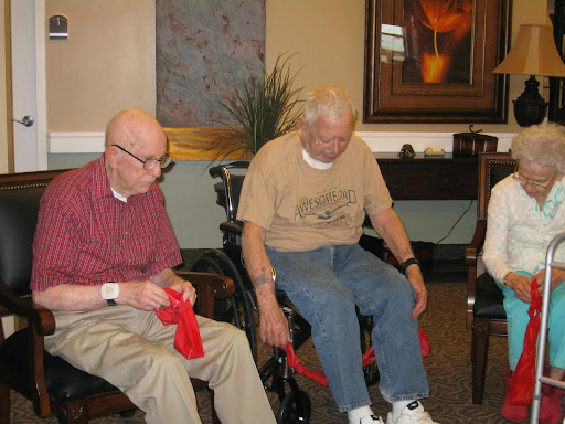 Two elderly men engaging in an activity at a care facility.