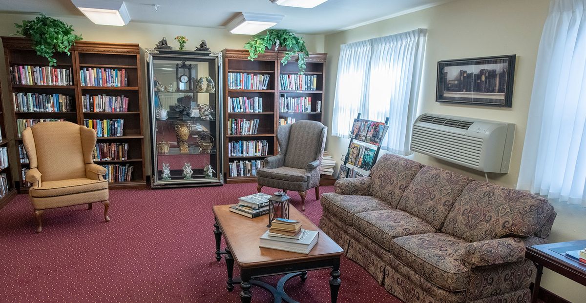 A cozy living room with bookshelves, a sofa, and a coffee table.