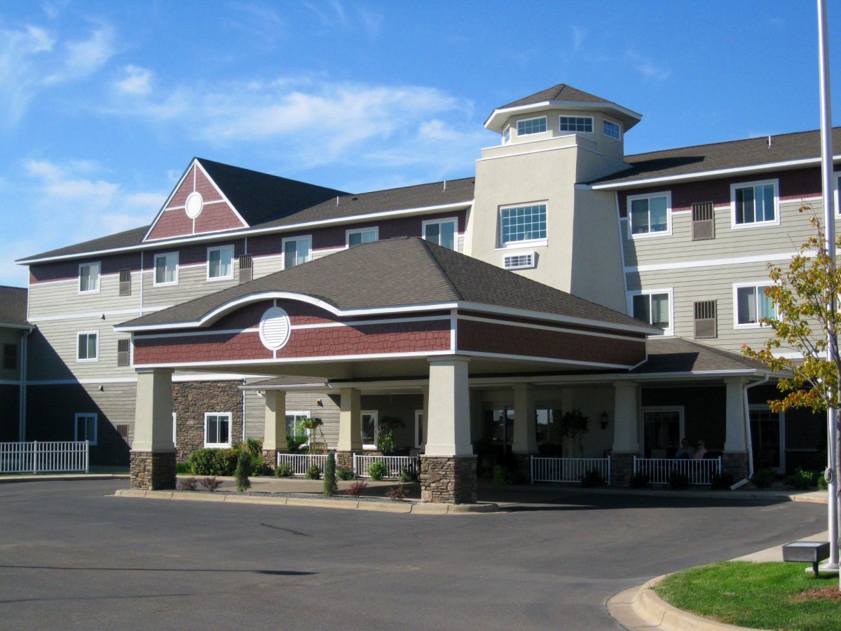 A modern hotel building with a welcoming entrance and clear blue skies.