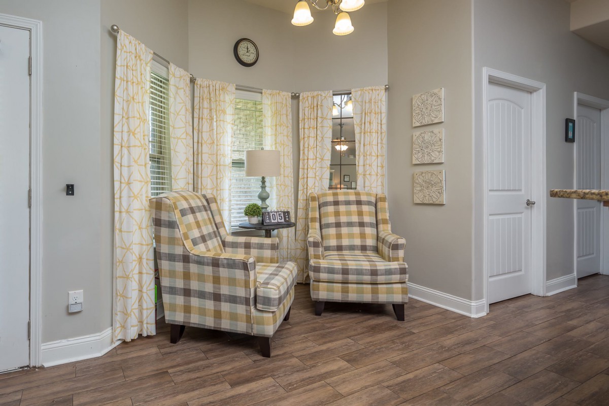 Cozy living room corner with plaid armchairs and soft lighting.