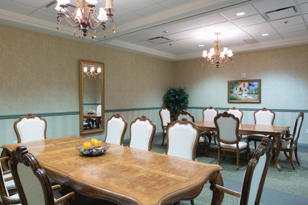 A formal dining room with elegant furniture and chandeliers.