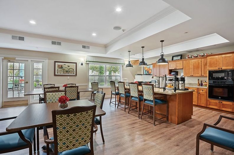 A cozy dining and kitchen area featuring wooden floors and elegant seating arrangements.
