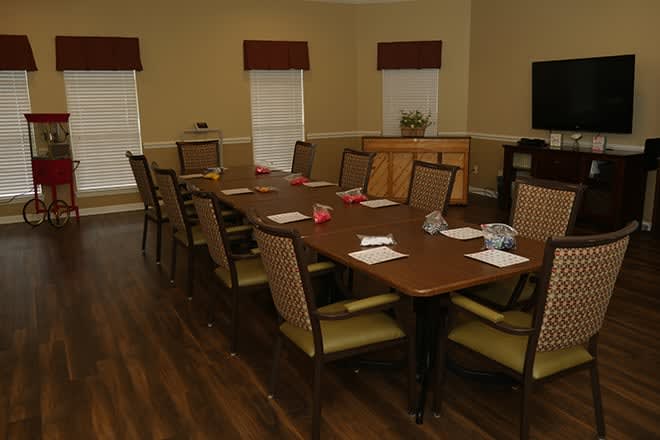 A well-arranged conference room with a long table surrounded by chairs, notepads placed neatly on the table.
