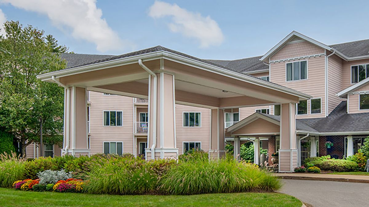 A large residential building with a covered entrance and well-maintained landscaping.