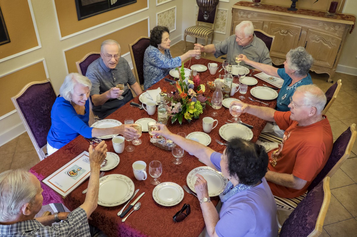 A group of elderly people enjoying a meal together around a beautifully set table.