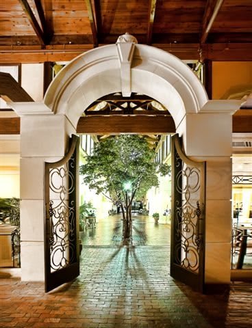 A beautifully lit archway leading to a tree-lined corridor.