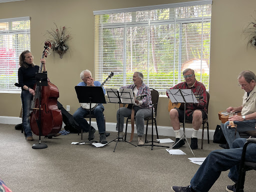 A group of senior musicians performing together in a cozy indoor setting.