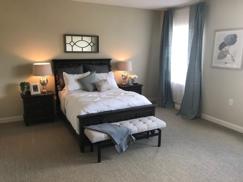 A well-furnished bedroom with a cozy bed, elegant decor, and soft lighting.