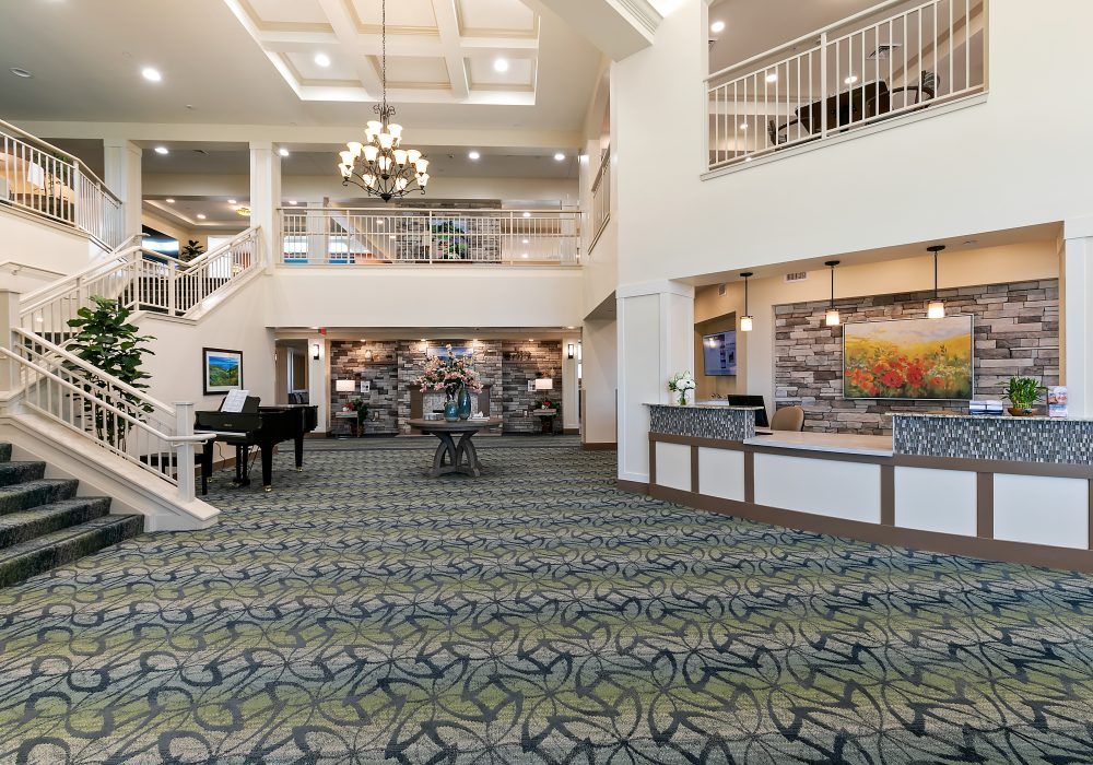 A spacious and elegant hotel lobby featuring a chandelier and reception desk.