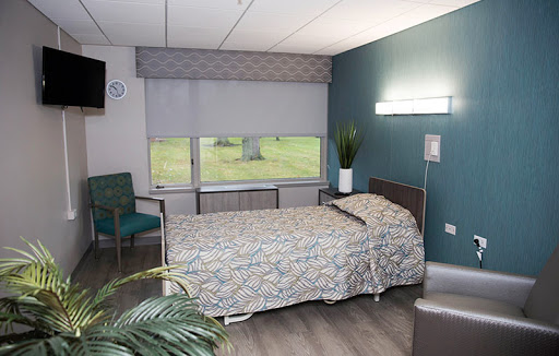 A modern hospital room featuring a bed, window with natural light, and tasteful decor.