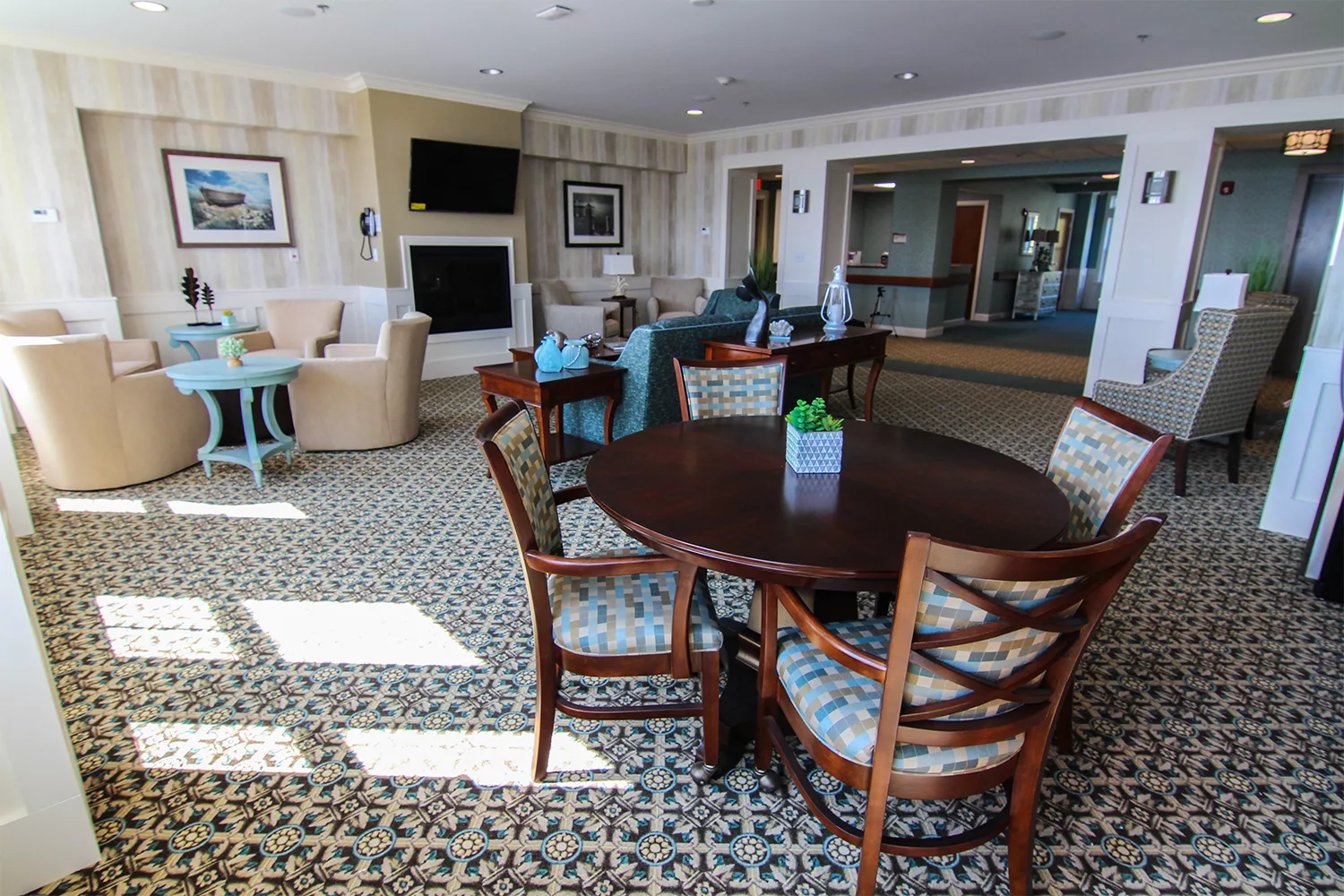 A well-lit living room with a round table, chairs, and modern decor.