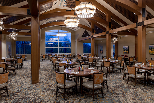 A spacious and elegantly designed dining area featuring wooden beams and stylish chandeliers.