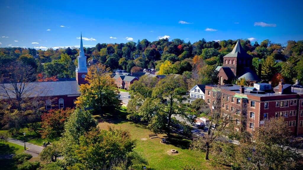 A picturesque view of a charming town with a church and historic buildings surrounded by autumn foliage.