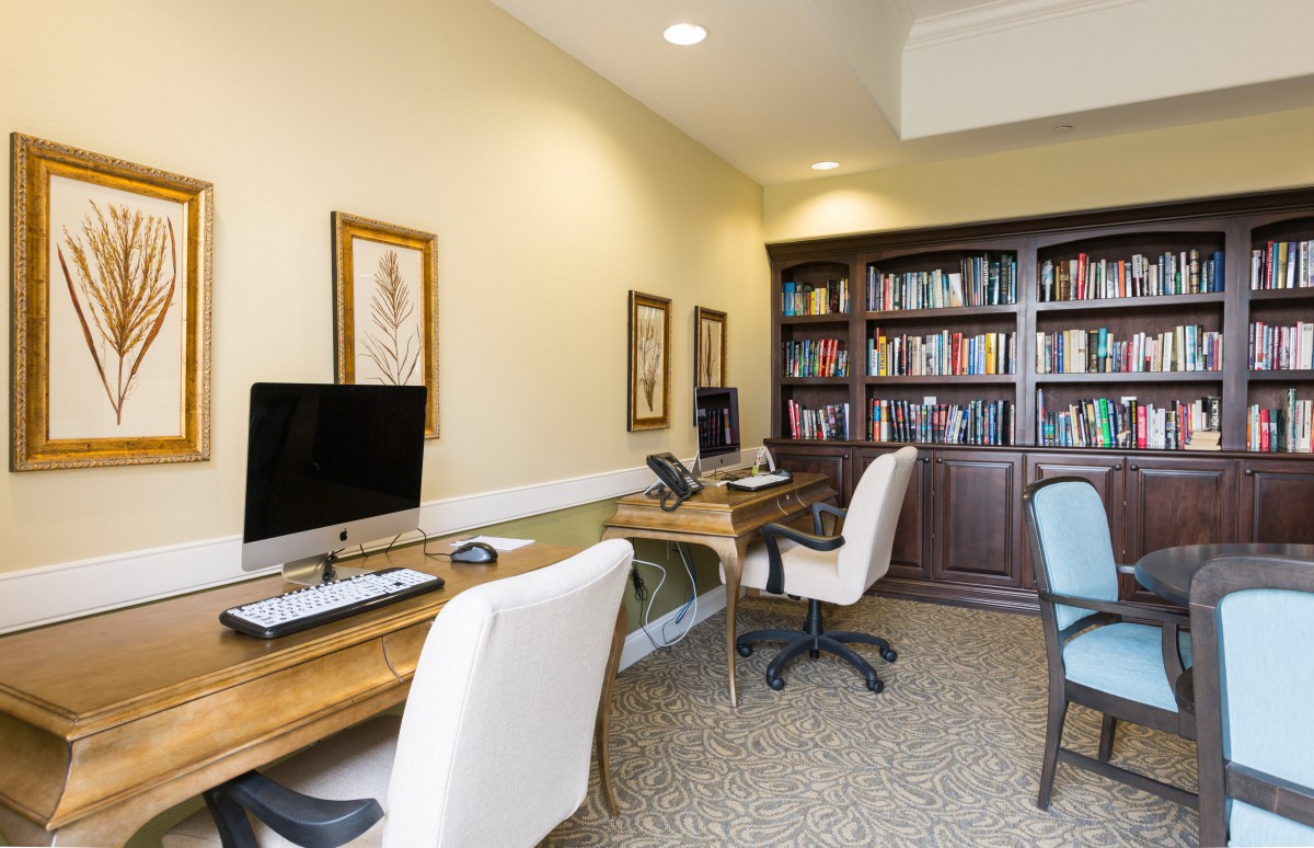 A well-organized office space with desks, computers, and a bookshelf filled with books.