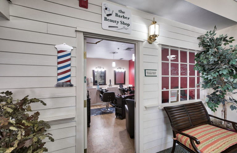 Entrance to a stylish barber and beauty shop with modern interior.