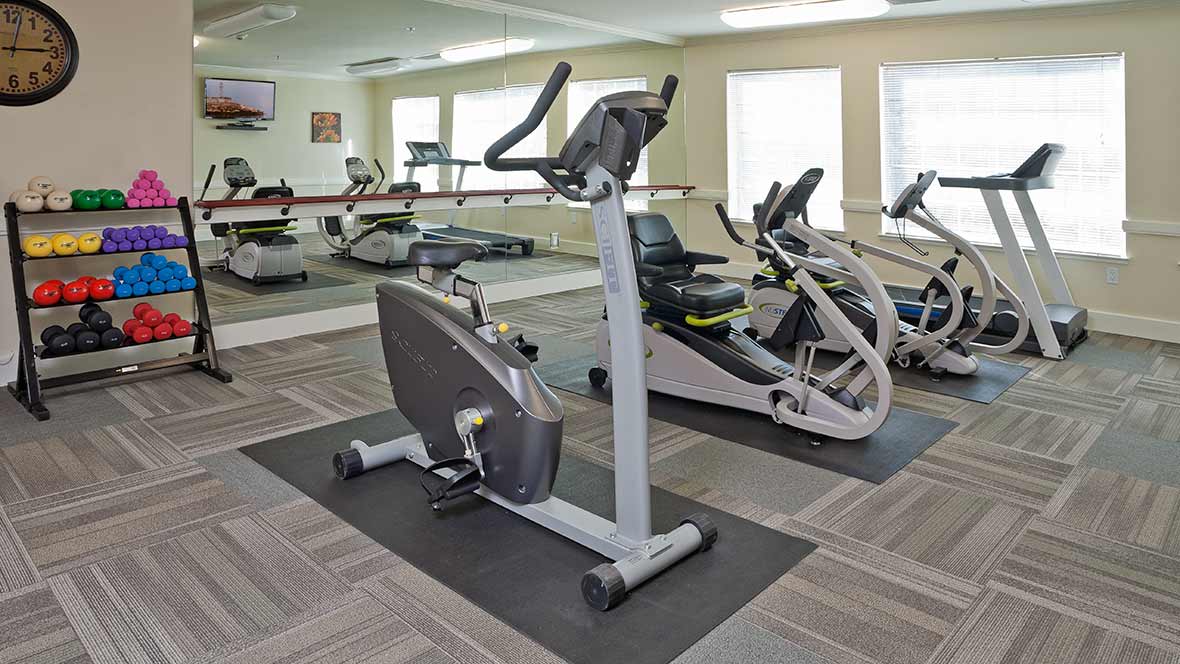 A gym featuring multiple exercise bikes and mirrors for indoor workouts.